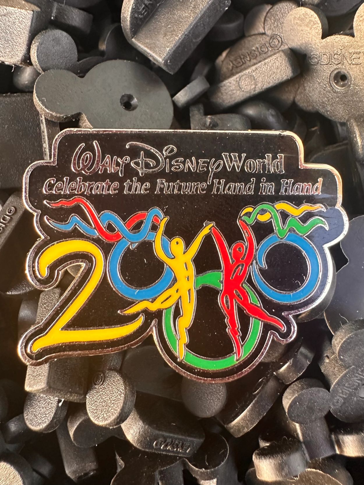 Walt Disney World 2000 pin with colorful figures and text.