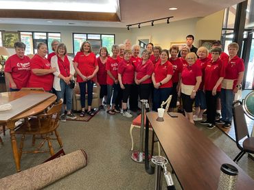 Group of people in red shirts gathered indoors.