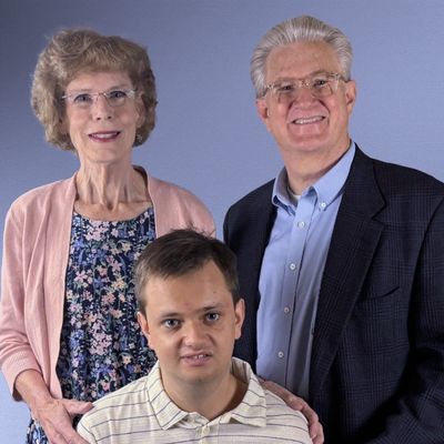 Smiling elderly couple with a younger man.