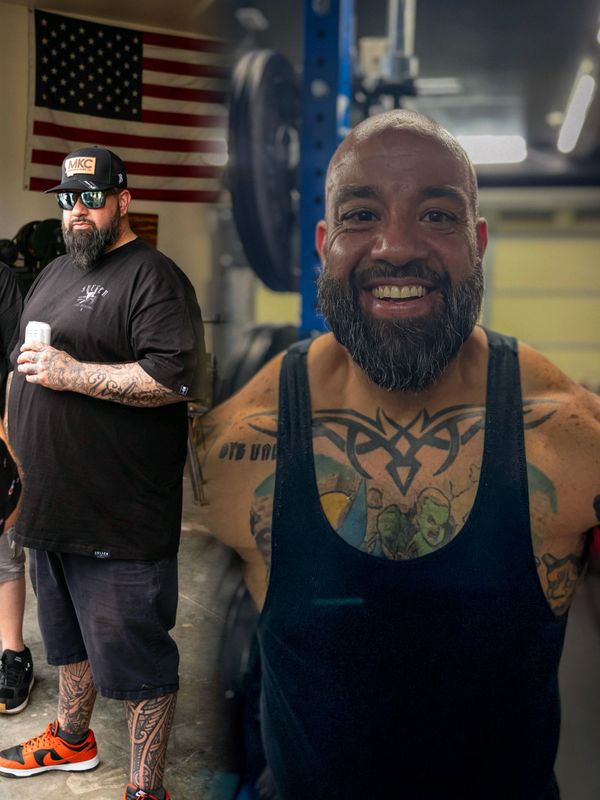 Two men with tattoos in a gym, one wearing a black tank top and smiling.