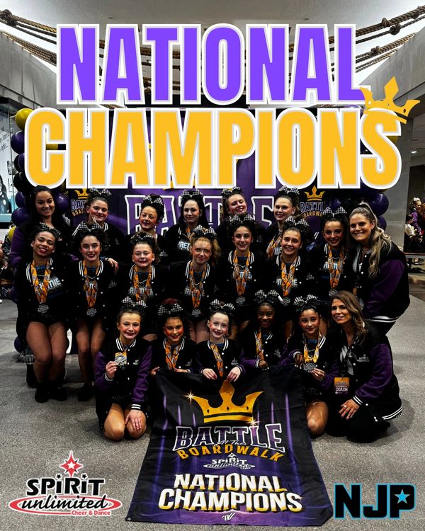 Cheerleading team celebrates their national championship victory with medals and banner.