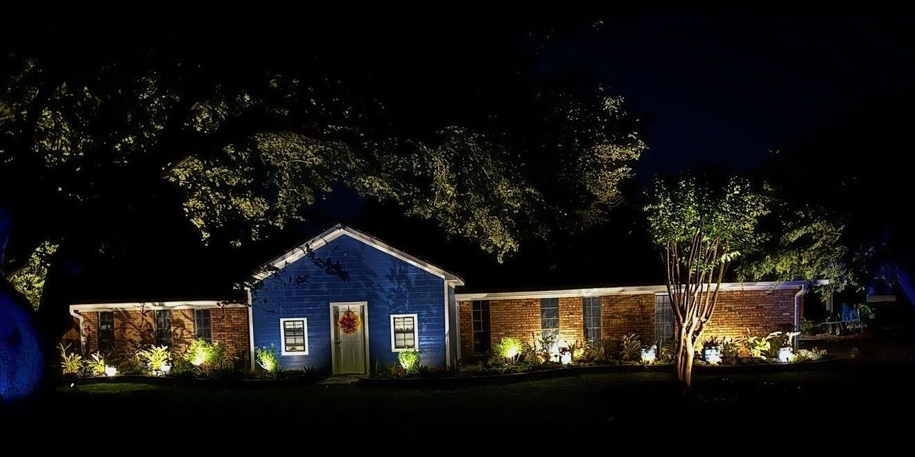 AMP landscape lighting at night on a Lake Charles home by Lawson Landscaping