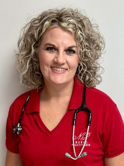 Smiling nurse practitioner with curly hair and stethoscope.