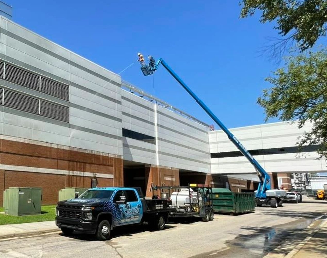 Workers use a lift to clean or repair the side of a large building.