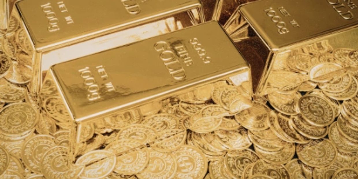 Several gold bars and numerous gold coins piled together.