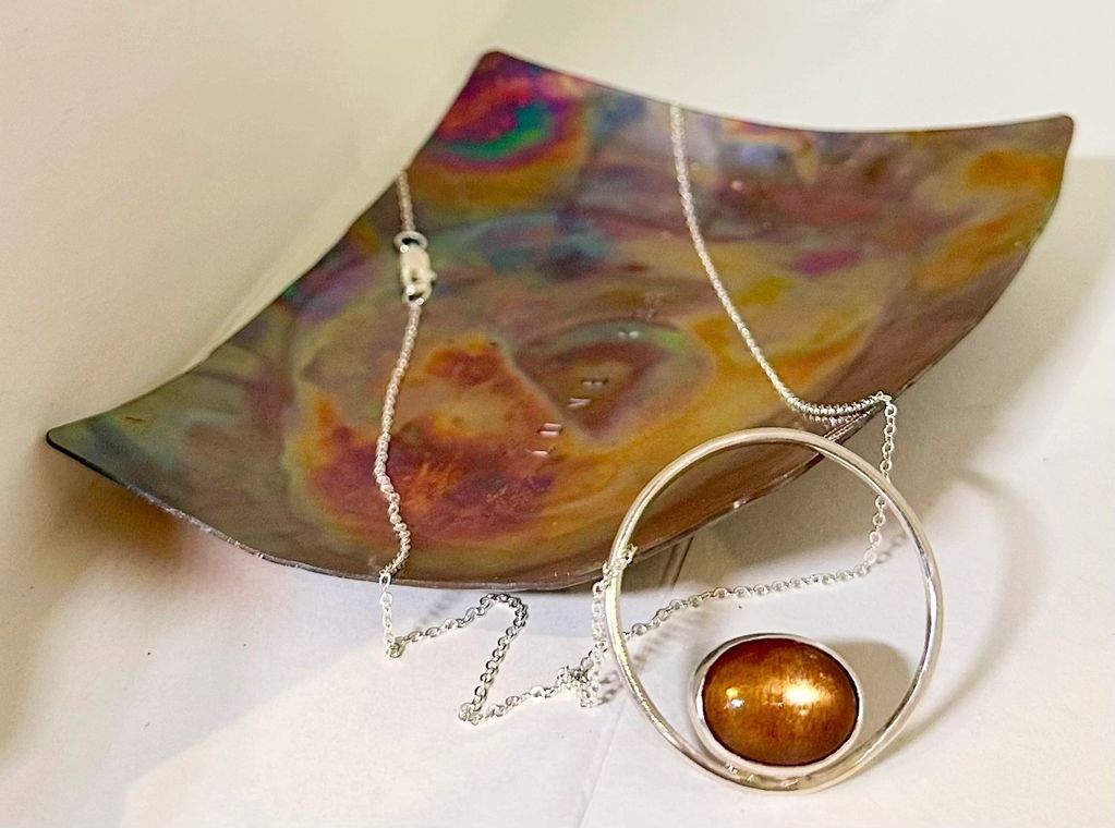 Star Sun stone ethically sourced form Norway set in hand crafted fine silver bezel O frame with a fl