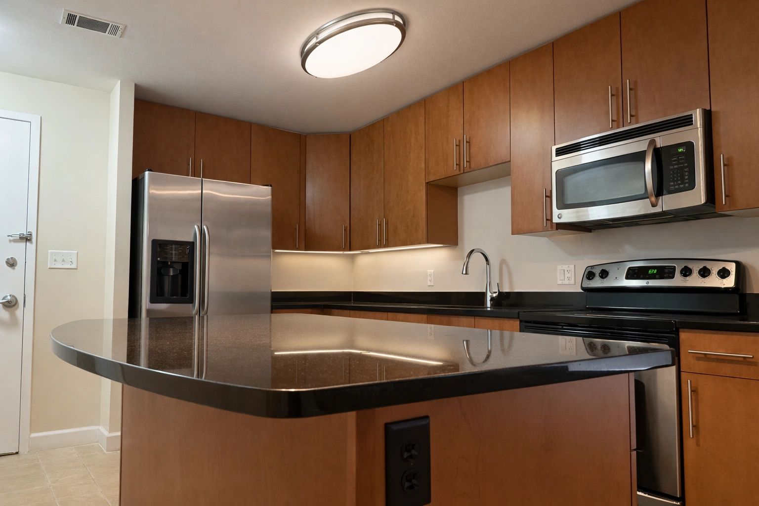 Modern kitchen with wooden cabinets and stainless steel appliances.