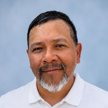 Smiling middle-aged man with a salt-and-pepper beard.