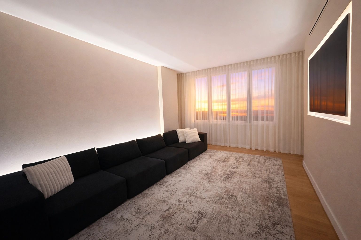 Modern living room with a long black sofa and sunset view through sheer curtains.