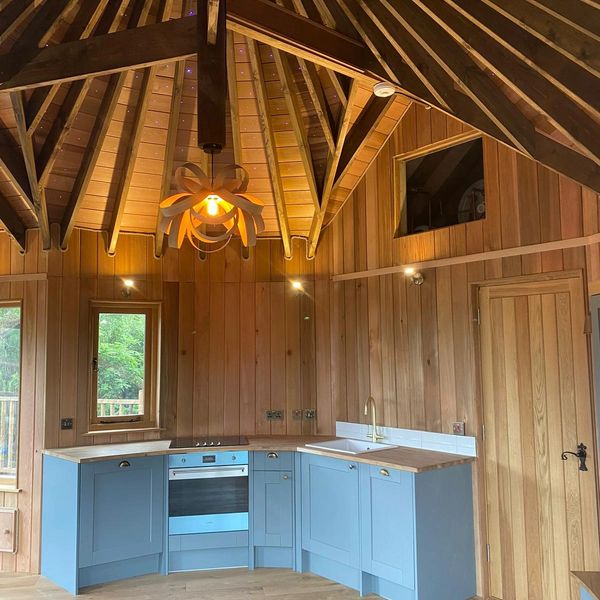 Cozy kitchen with wooden walls and blue cabinets.