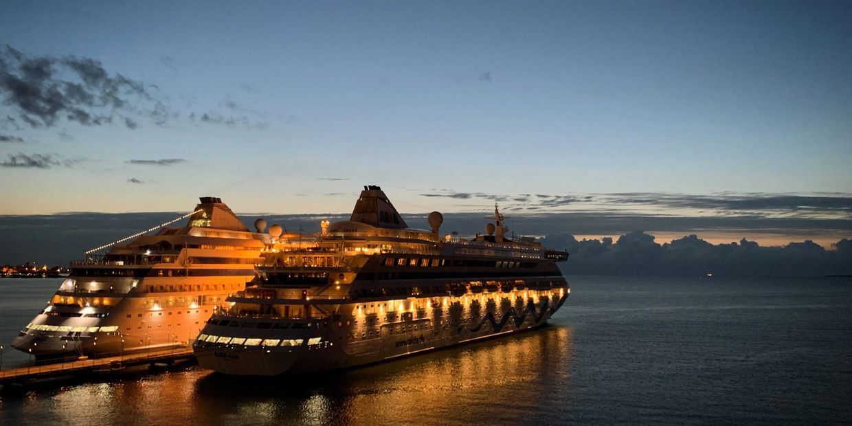 Cruise ship silhouetted against a golden sunset on open ocean – ideal for ash scattering at sea.