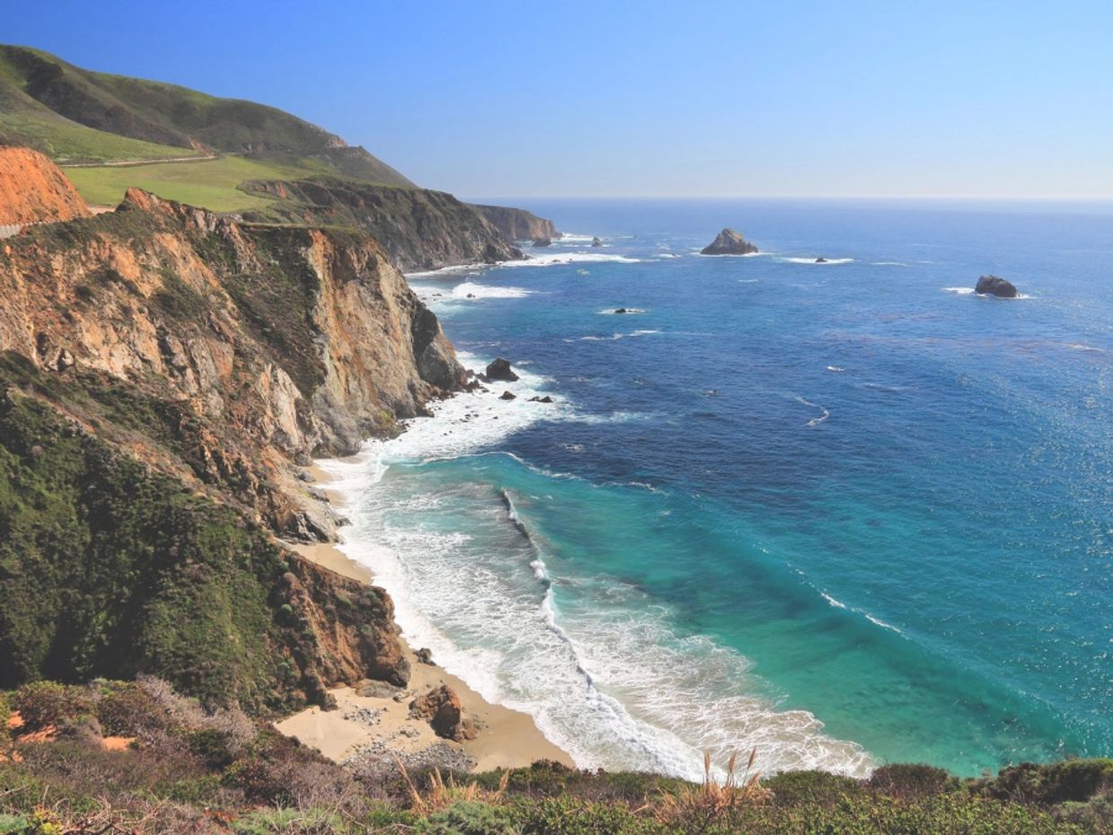 Pacific coastline in California at sunset with title text “Scattering Ashes in California” represent