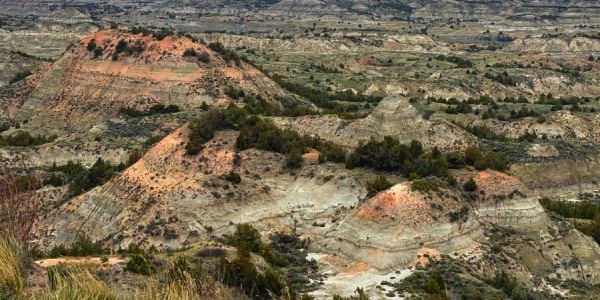 A rugged landscape with layered hills and sparse vegetation.