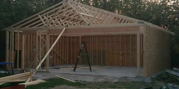 Wooden frame structure of a building under construction at dusk.