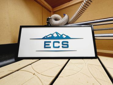 A framed ECS logo with mountain design inside a workshop.