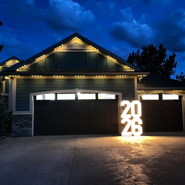 A house at night with illuminated 2026 sign near garage doors.