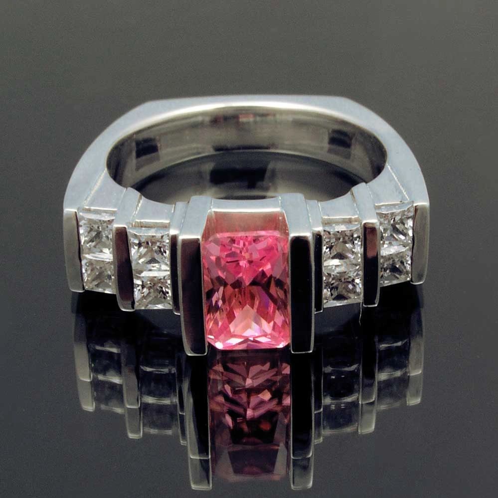 Sterling silver ring with pink CZ center and white princess cut  CZs on the sides.