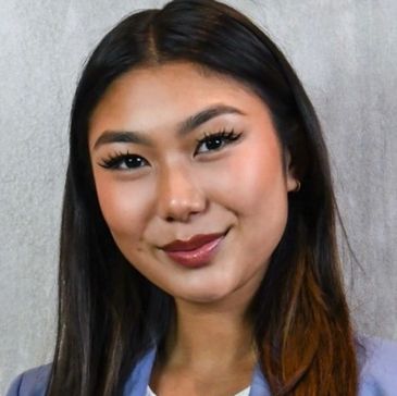 Portrait of a confident young woman with long dark hair and a subtle smile.