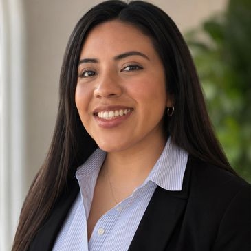 Professional young woman smiling confidently in business attire.