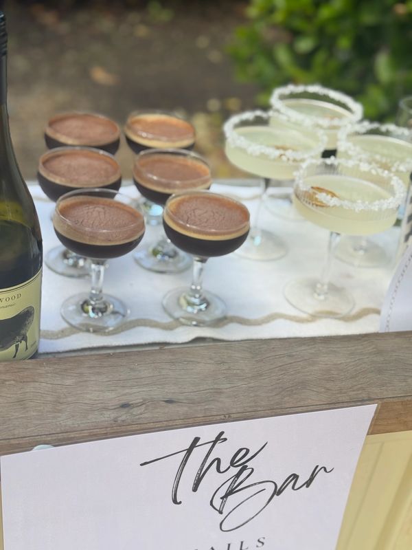 A bar setup with espresso martinis and margaritas on a table.