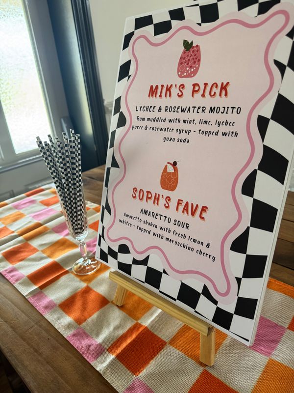 A menu board displaying two cocktail picks on a checkered background.