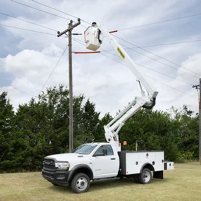 Aerial placement crew with bucket truck installing fiber optic cable on utility poles
