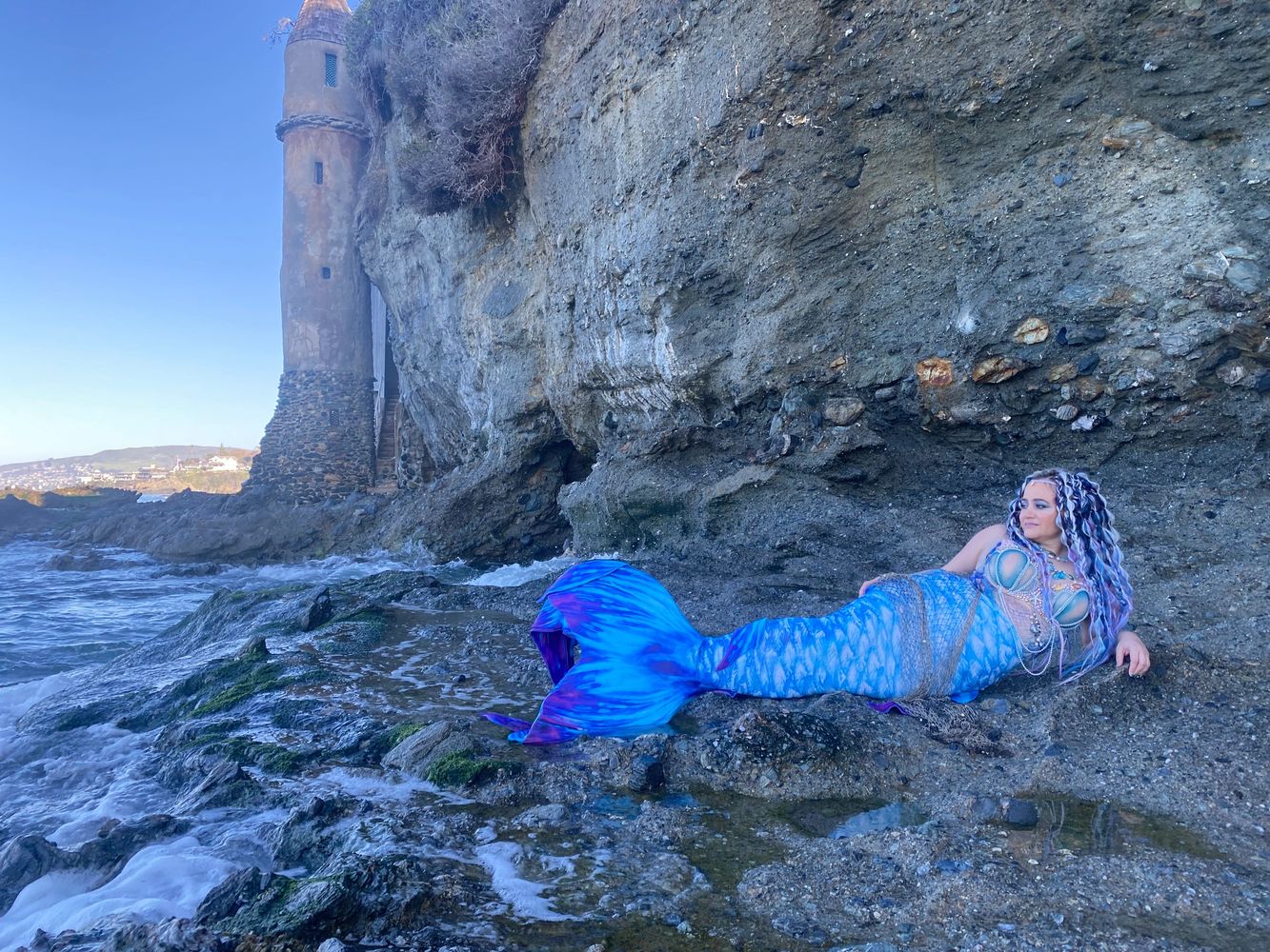 Mermaid Bree lounging on the rocks of Victoria Beach, CA