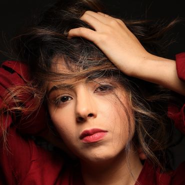 Woman with expressive eyes holding her hair.