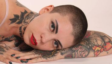 Woman with tattoos. head resting on arm