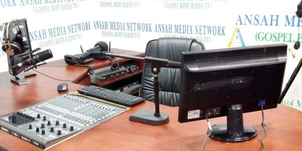 Radio studio setup with microphone and computer.