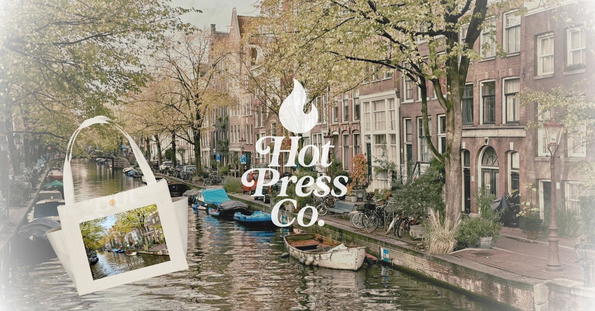 A serene canal scene in Amsterdam with boats and autumn trees.