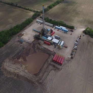 Aerial view of an oil drilling site in a rural area.