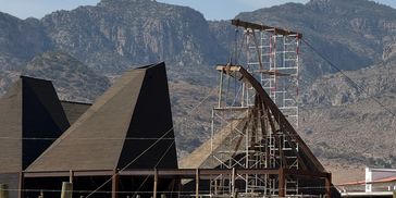 Estructuras piramidales negras con montañas al fondo.