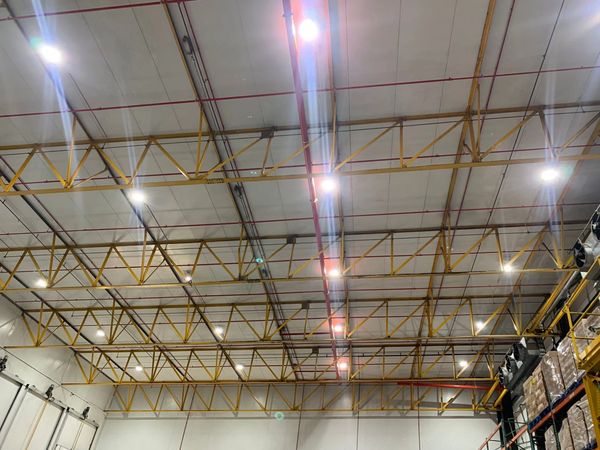 Industrial ceiling with metal framework and bright lights.