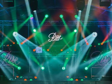 Colorful stage lighting with the word 'Rise' illuminated.