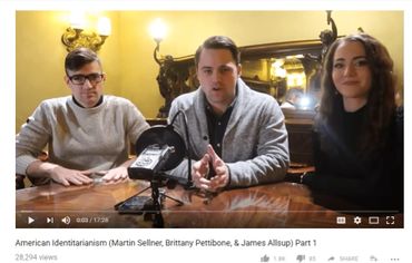 Three people sit at a table discussing American Identitarianism in a video.