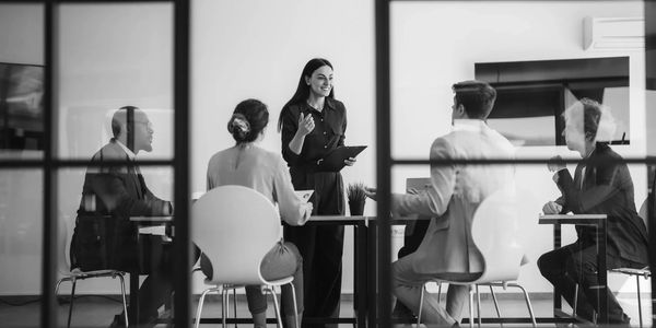 Business meeting with a woman presenting to colleagues.