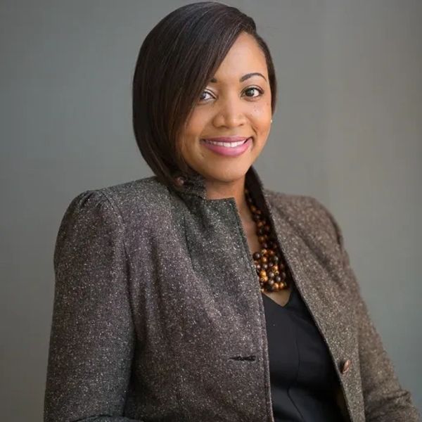 Professional woman smiling confidently in business attire.