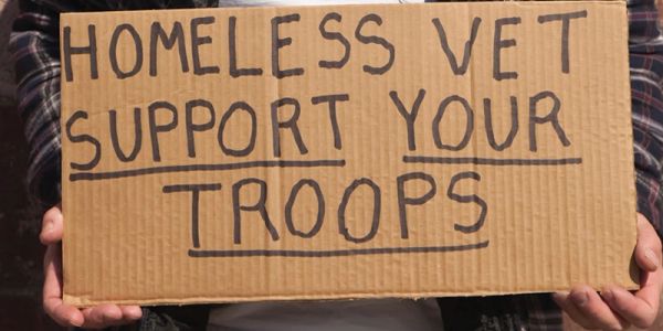 Sign reads 'Homeless Vet Support Your Troops.'