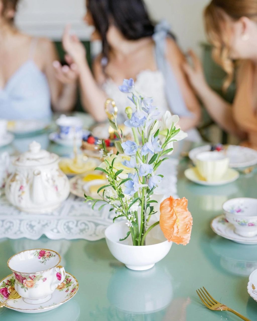 Vintage teacup with floral arrangement on bridal tea party table