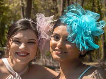 2 ladies wearing dresses and fascinators