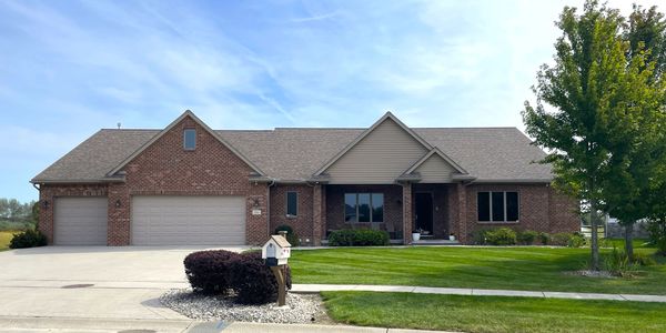 Modern single-story brick house with a well-kept lawn.