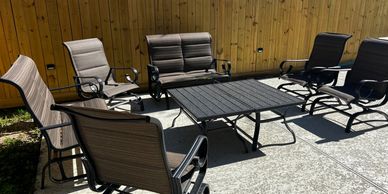 Outdoor patio seating set with six chairs and a table.