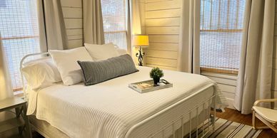 Cozy bedroom with white bed and rustic decor.