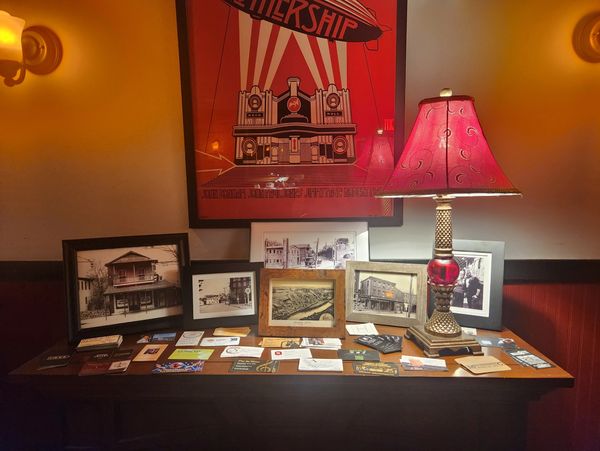 Table with framed photos, business cards, and a red lamp in warm lighting.