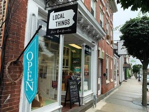 Local Things store with an open sign on a city sidewalk.