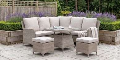 Outdoor wicker patio set with beige cushions and a wooden table.