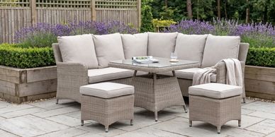 Outdoor wicker patio set with beige cushions and a wooden table.