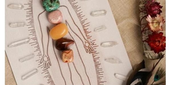 Healing crystals placed on a body outline for chakra alignment.