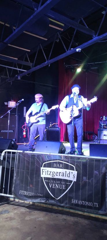 Two musicians performing live on stage at Fitzgerald's Bar in San Antonio, TX.